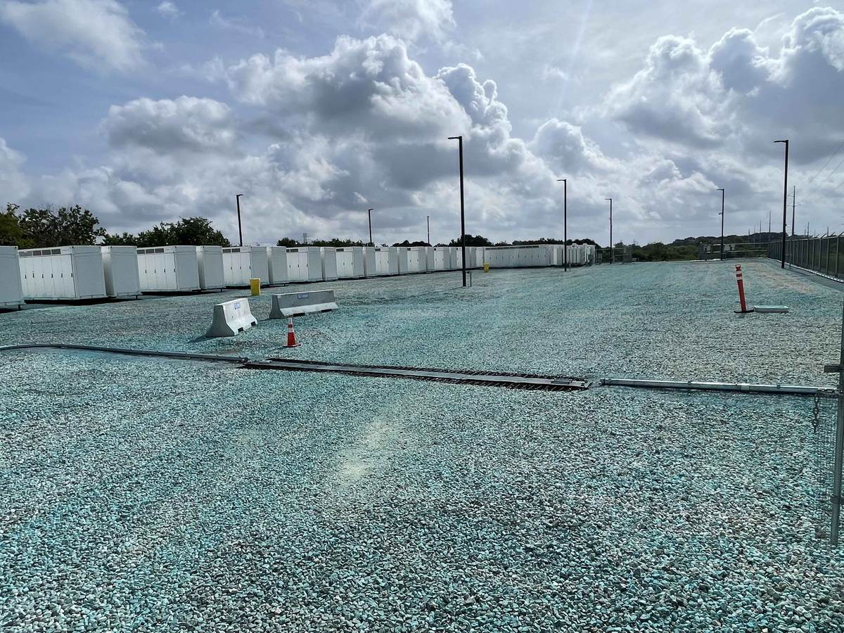 Long rows of battery storage containers on a treated gravel yard